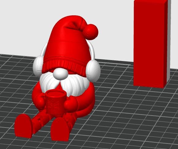 May include: A 3D rendered red gnome figurine wearing a tall red hat and white earmuffs. The gnome has a white beard, is sitting down, and is holding a small red mug with both hands. A tall red rectangular block stands to the right of the gnome.
