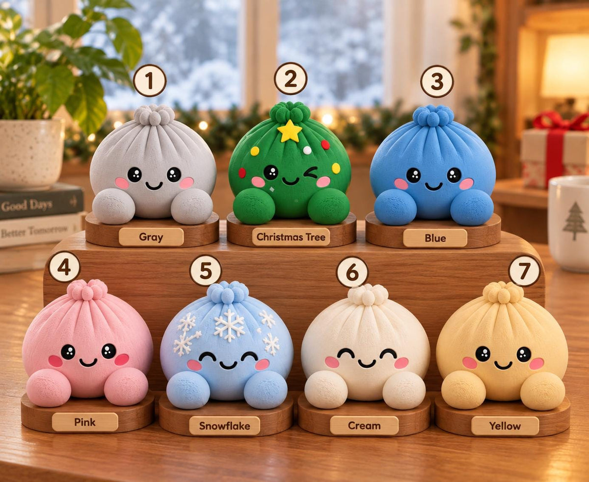 May include: Seven round, dumpling-shaped figurines with smiling faces, each on a wooden base. Colors include gray, green with a yellow star, blue, pink, light blue with white snowflakes, cream, and yellow. Each has a numbered label from 1 to 7.