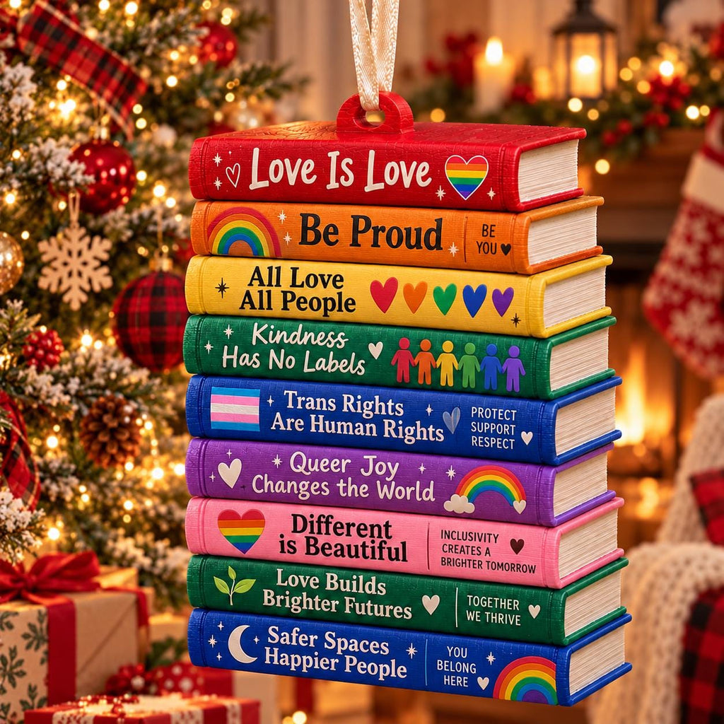 May include: A hanging ornament shaped like a stack of nine colorful books. Each spine features text and symbols: Love Is Love, Be Proud, All Love All People, Kindness Has No Labels, Trans Rights Are Human Rights, Queer Joy Changes the World, Different is Beautiful, Love Builds Brighter Futures, and Safer Spaces Happier People.