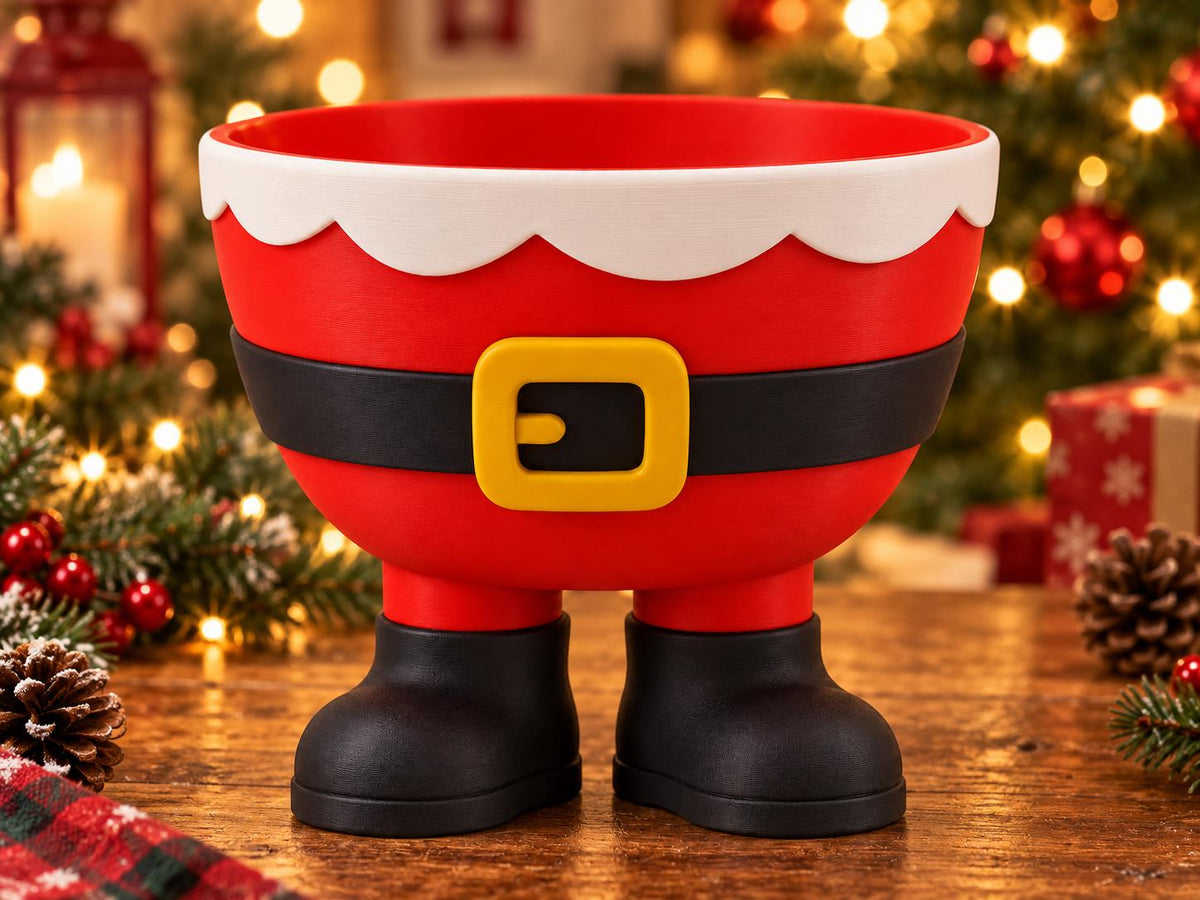 May include: A red bowl shaped like the lower body of Santa Claus, featuring a white scalloped trim at the top, a black belt with a yellow buckle around the center, and two black boots serving as the base for the bowl to stand upright.