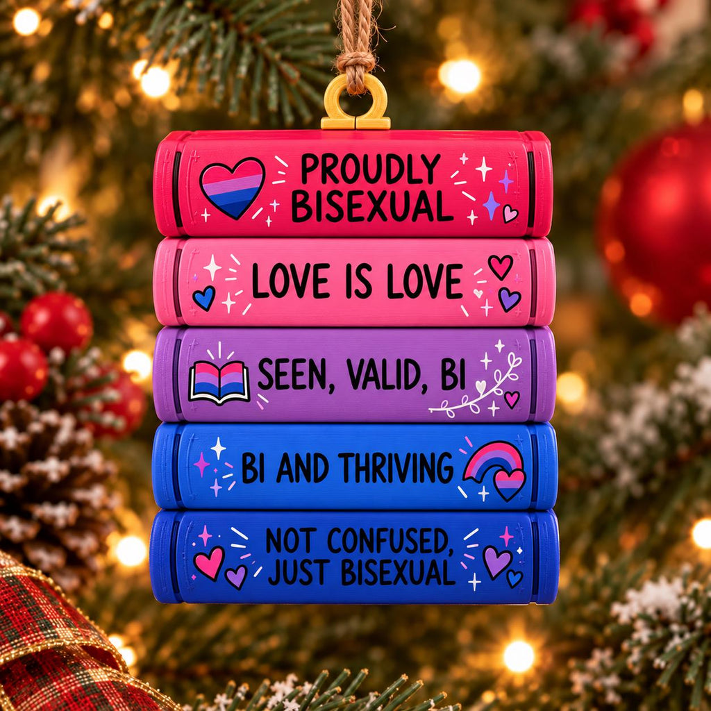 May include: A stack of five rectangular, book-shaped ornaments in pink, purple, and blue. The text reads: PROUDLY BISEXUAL, LOVE IS LOVE, SEEN, VALID, BI, BI AND THRIVING, and NOT CONFUSED, JUST BISEXUAL, decorated with hearts and stars.