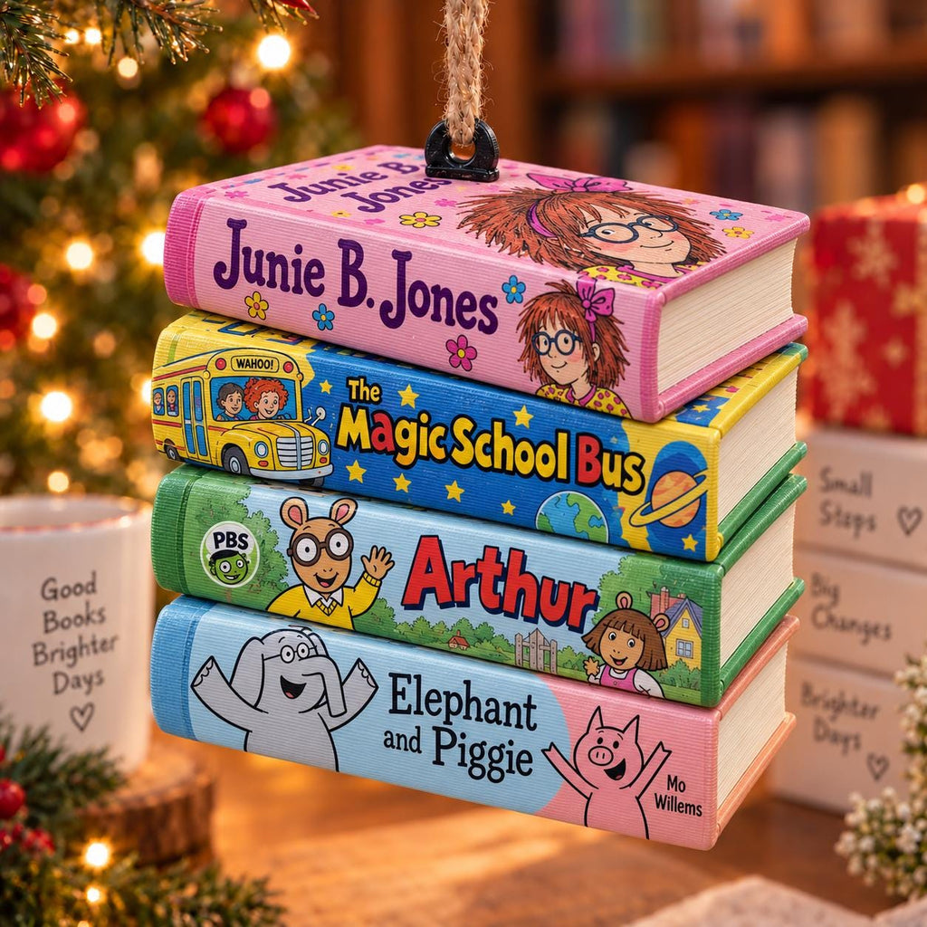 May include: A stack of four book-shaped ornaments hanging from a jute rope. The top book is pink with Junie B. Jones text and illustrations. Below is a yellow Magic School Bus book, a green Arthur book, and a light blue Elephant and Piggie book.