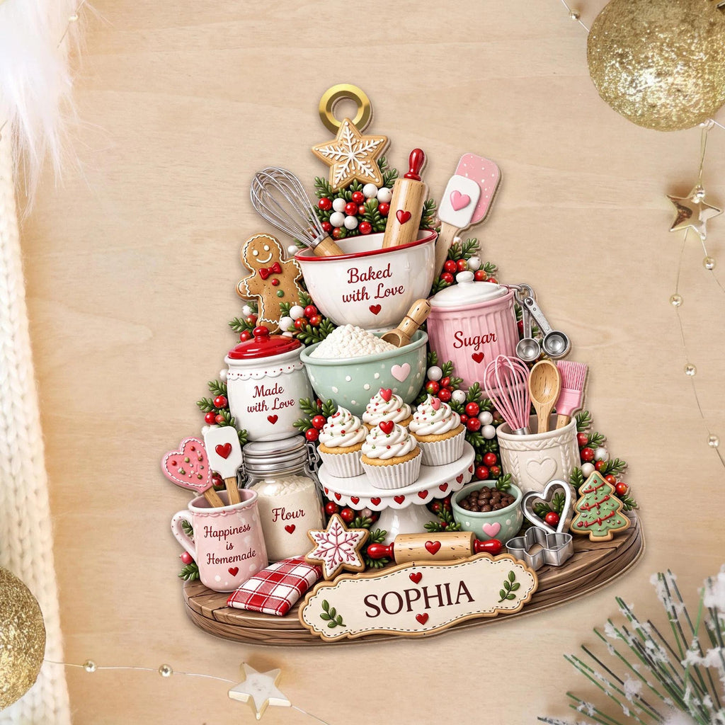 May include: A decorative wall hanging shaped like a Christmas tree featuring baking items including a mixing bowl with the text Baked with Love, a sugar canister, a flour jar, cupcakes, a gingerbread man, and a sign at the base with the name SOPHIA.