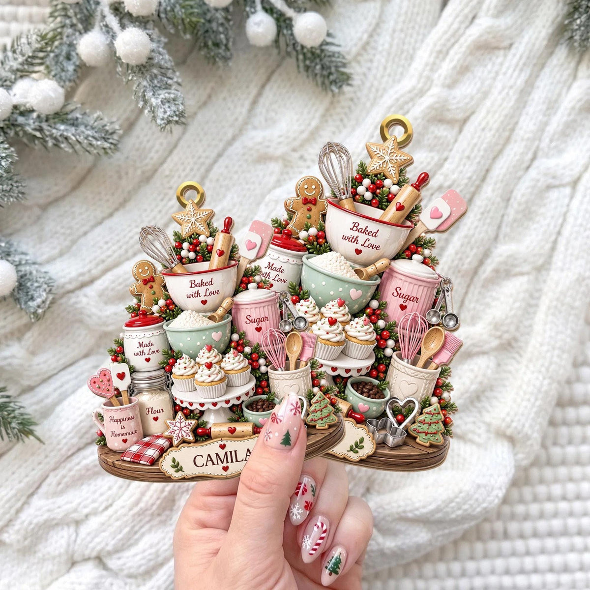 May include: A decorative ornament shaped like a baking scene featuring miniature bowls, whisks, rolling pins, cupcakes, and gingerbread cookies. The piece includes text reading Baked with Love, Made with Love, Sugar, Flour, and the name CAMILA on a base.