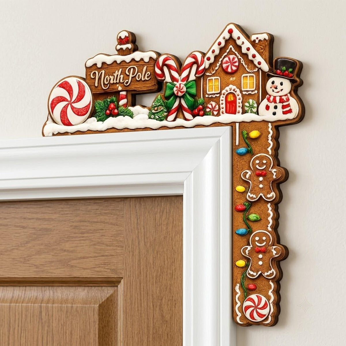Christmas corner door topper featuring a gingerbread house, North Pole sign, candy canes, snowman, peppermint candy, and festive lights mounted on a wooden door frame.