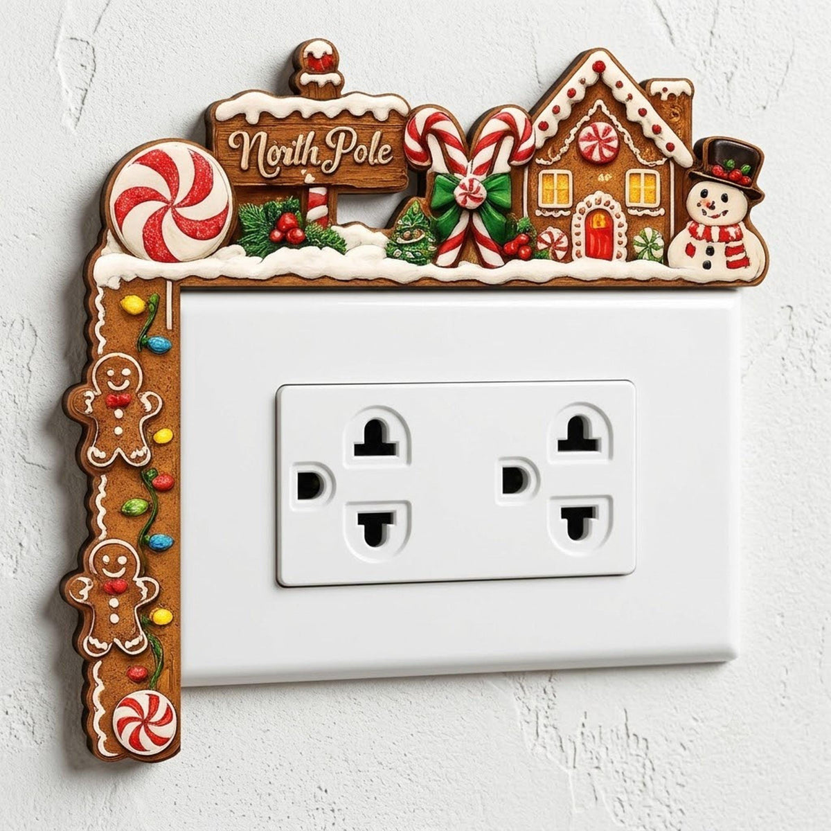 May include: A decorative Christmas-themed light switch cover featuring a gingerbread house, a North Pole sign, candy canes, and two gingerbread cookies. The frame is brown with white icing details, colorful holiday lights, and a snowman figure.