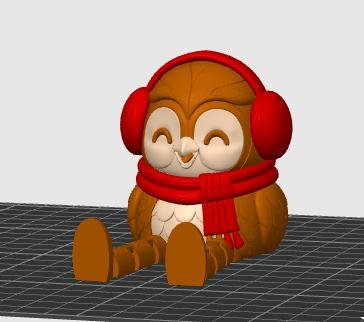 May include: A brown owl figurine with a cream-colored belly, wearing bright red earmuffs and a matching red scarf. The owl has a smiling expression with closed eyes and is depicted in a seated position with its legs extended forward.