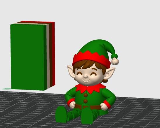 May include: A 3D rendered elf figurine with a green and red hat, a green jacket with brown buttons, and a brown belt. Beside the elf stands a rectangular block featuring vertical stripes of green, white, brown, and red colors on a grid surface.