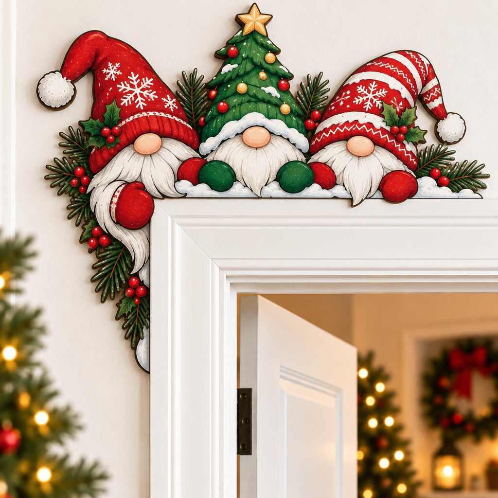 May include: A decorative wooden door corner sign featuring two gnomes in red and white snowflake-patterned hats flanking a central Christmas tree. The design includes green pine branches, red holly berries, and white snow accents on the edges.