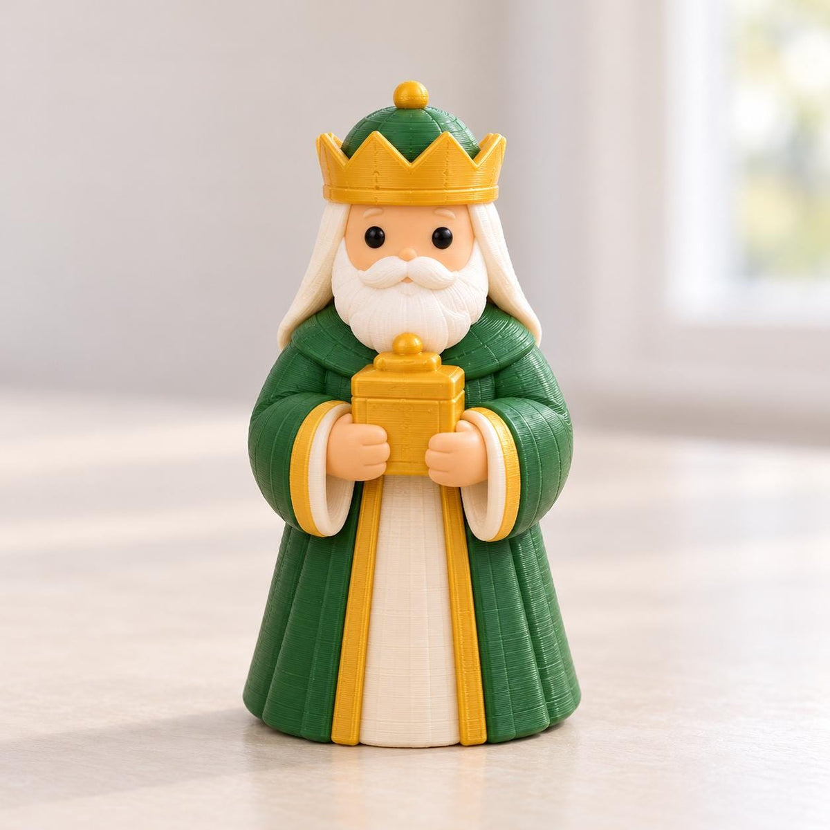 May include: A figurine of a king with a white beard, wearing a green robe with yellow trim and a yellow crown. The figure has a light skin tone, black eyes, and holds a small yellow rectangular box in both hands against a white robe.
