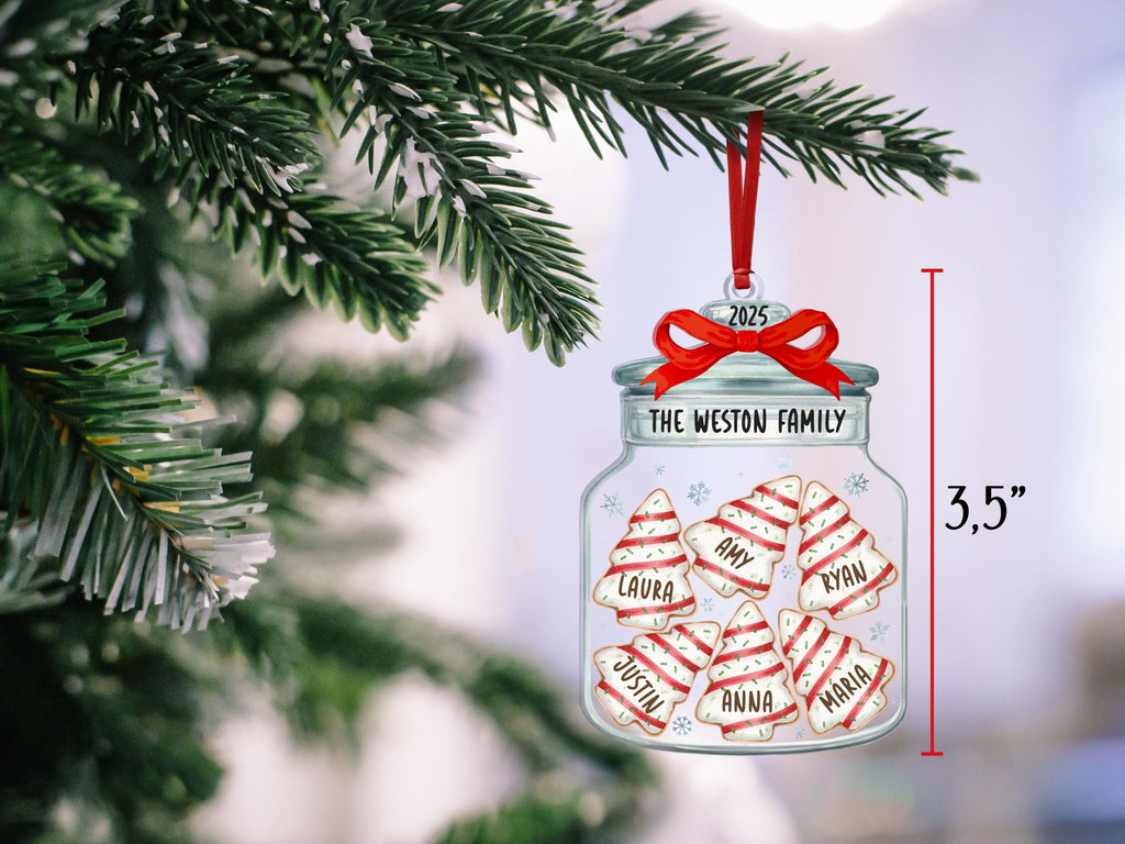 May include: A clear glass jar ornament featuring a red ribbon bow, the text 2025, and THE WESTON FAMILY. Inside are six white and red striped Christmas tree cookies labeled with the names Laura, Amy, Ryan, Justin, Anna, and Maria. It measures 3.5 inches.