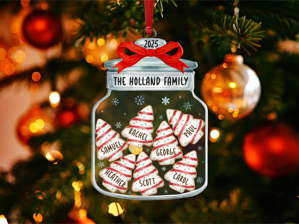 May include: A flat, jar-shaped Christmas ornament featuring a red ribbon at the top and the text 2025 and THE HOLLAND FAMILY. Inside the jar are seven white, tree-shaped cookies with red stripes and sprinkles, each personalized with a name.