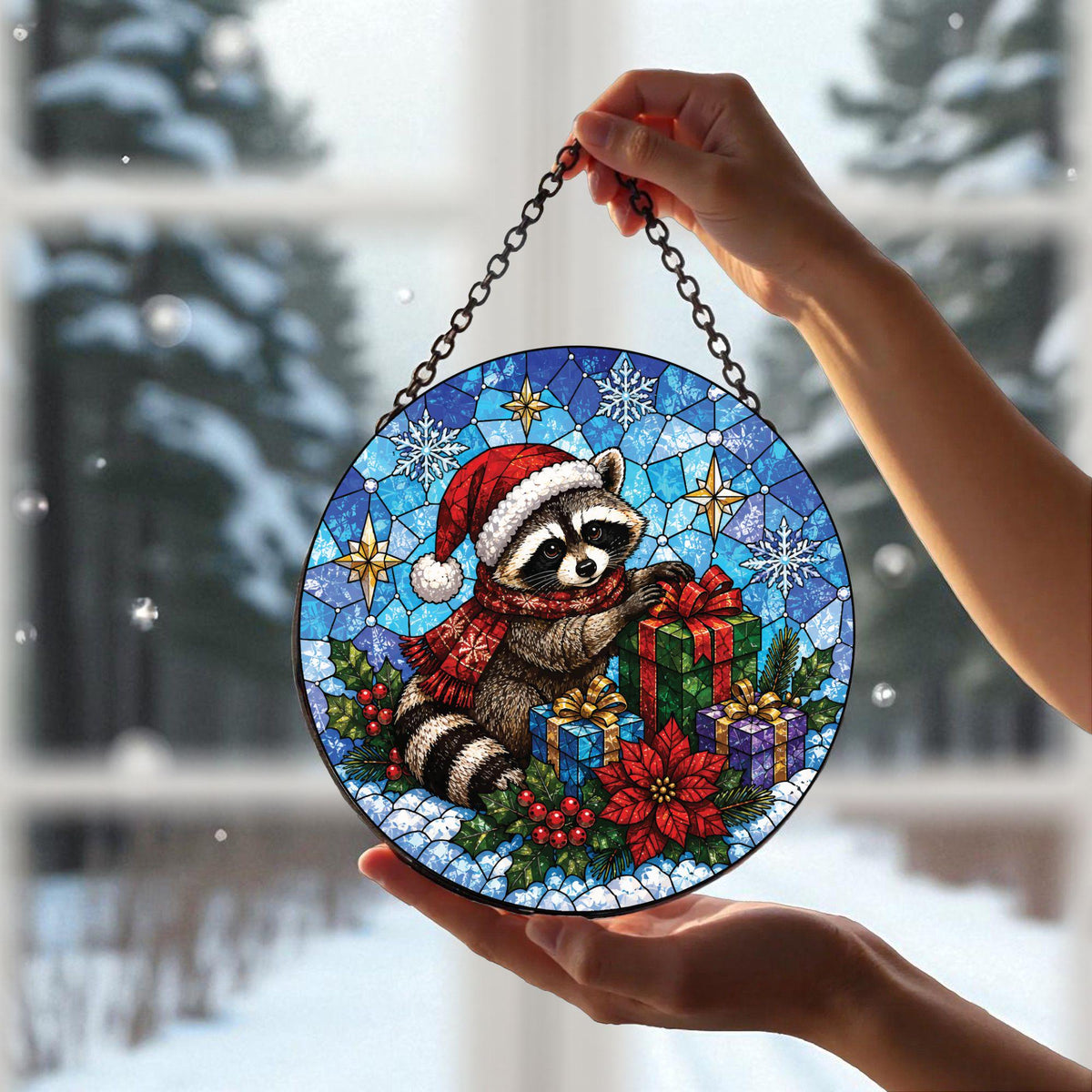 May include: A circular stained glass suncatcher featuring a raccoon wearing a red Santa hat and scarf, surrounded by wrapped gifts, holly, and poinsettias against a blue snowflake background, suspended by a black metal chain for display.