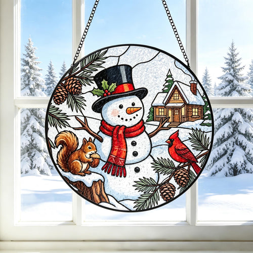 May include: A circular stained glass suncatcher featuring a central snowman wearing a black top hat and red scarf, flanked by a brown squirrel holding a nut and a red cardinal bird on a pine branch, with a snow-covered cabin in the background.