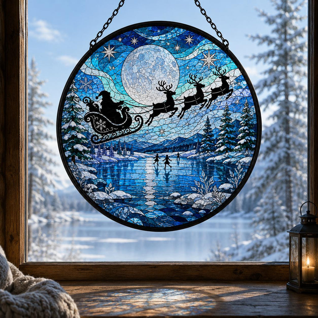 Winter stained glass suncatcher featuring Santa and reindeer flying across a full moon above a frozen blue lake, snowy pine trees, and mountain landscape.