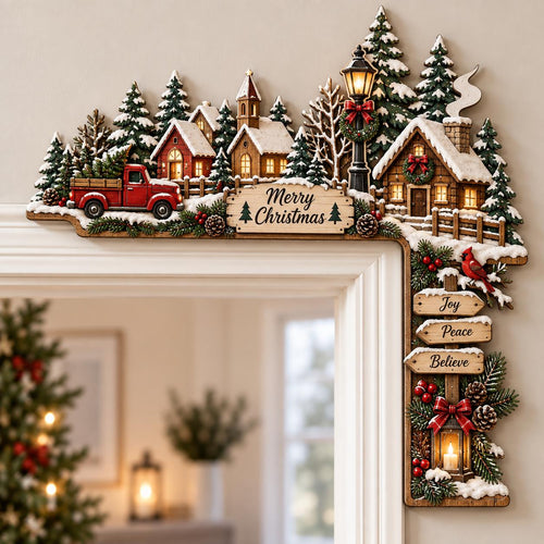 May include: A wooden Christmas door corner decoration featuring a snowy village scene with a red truck, houses, pine trees, and a street lamp. A sign reads Merry Christmas, while hanging signs below display the words Joy, Peace, and Believe.