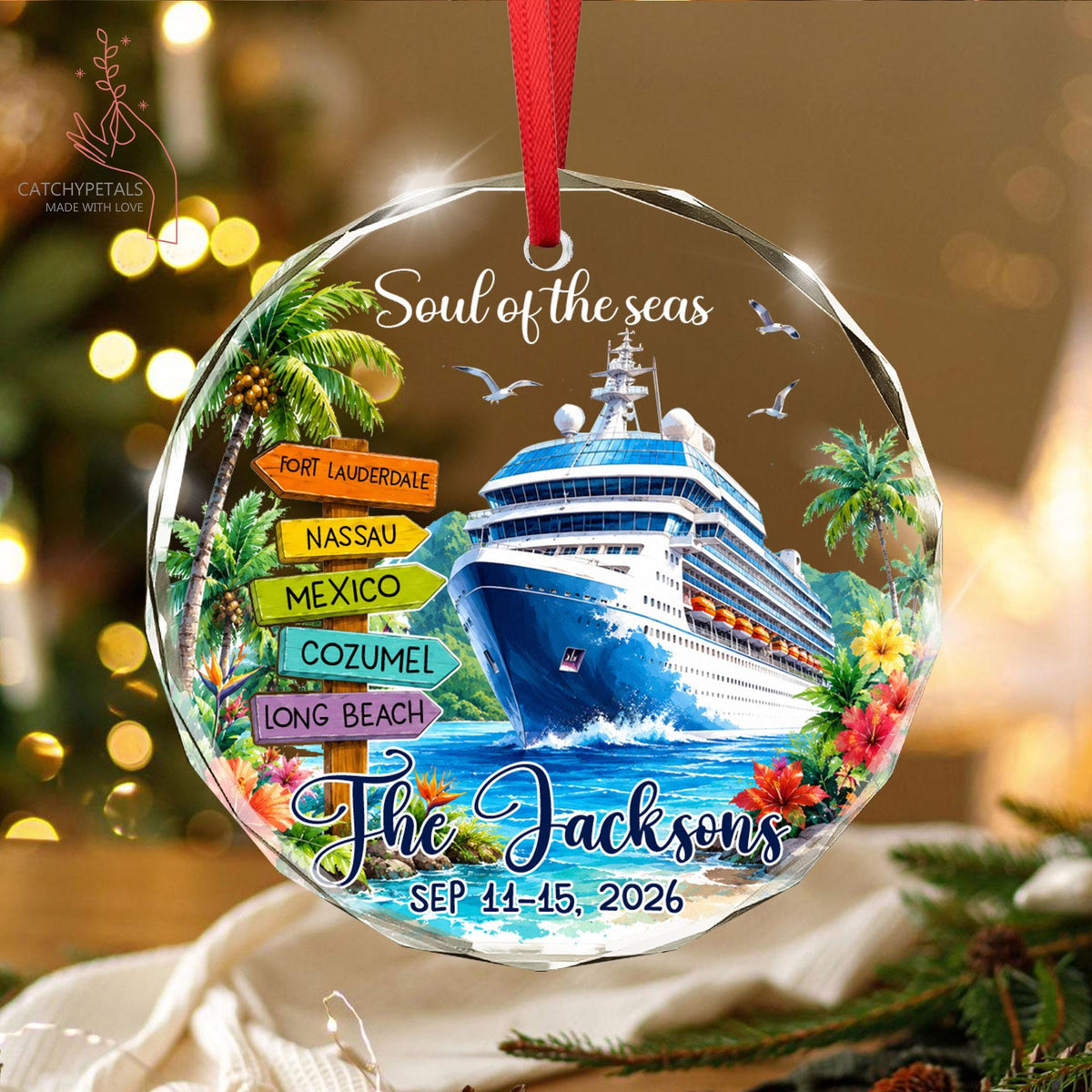 May include: A round, clear acrylic ornament with a red ribbon, featuring a cruise ship on blue water, palm trees, and a wooden signpost with the text Fort Lauderdale, Nassau, Mexico, Cozumel, Long Beach, Soul of the seas, The Jacksons, SEP 11-15, 2026.