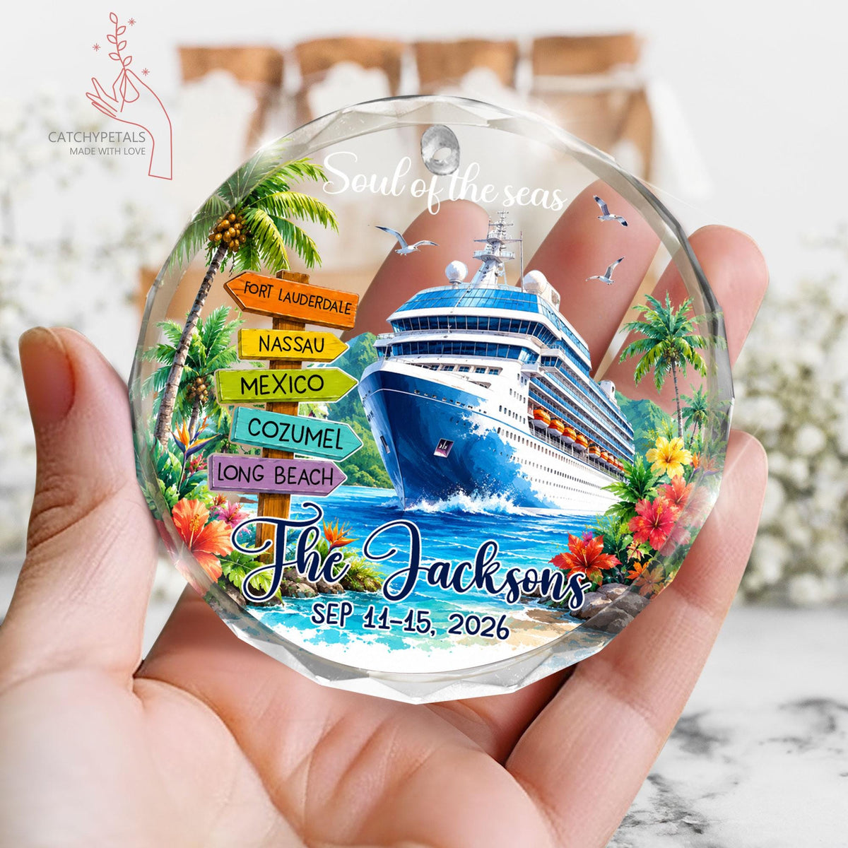 May include: A round, faceted glass ornament featuring a cruise ship on blue water, a wooden signpost with locations Fort Lauderdale, Nassau, Mexico, Cozumel, and Long Beach, tropical flowers, palm trees, and the text Soul of the seas, The Jacksons, SEP 11-15, 2026.