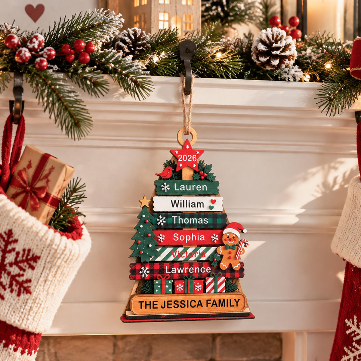 May include: A wooden Christmas tree ornament featuring horizontal slats with the names Lauren, William, Thomas, Sophia, Victoria, and Lawrence. It includes a red star labeled 2026, a gingerbread man, a small tree, and a base reading THE JESSICA FAMILY.