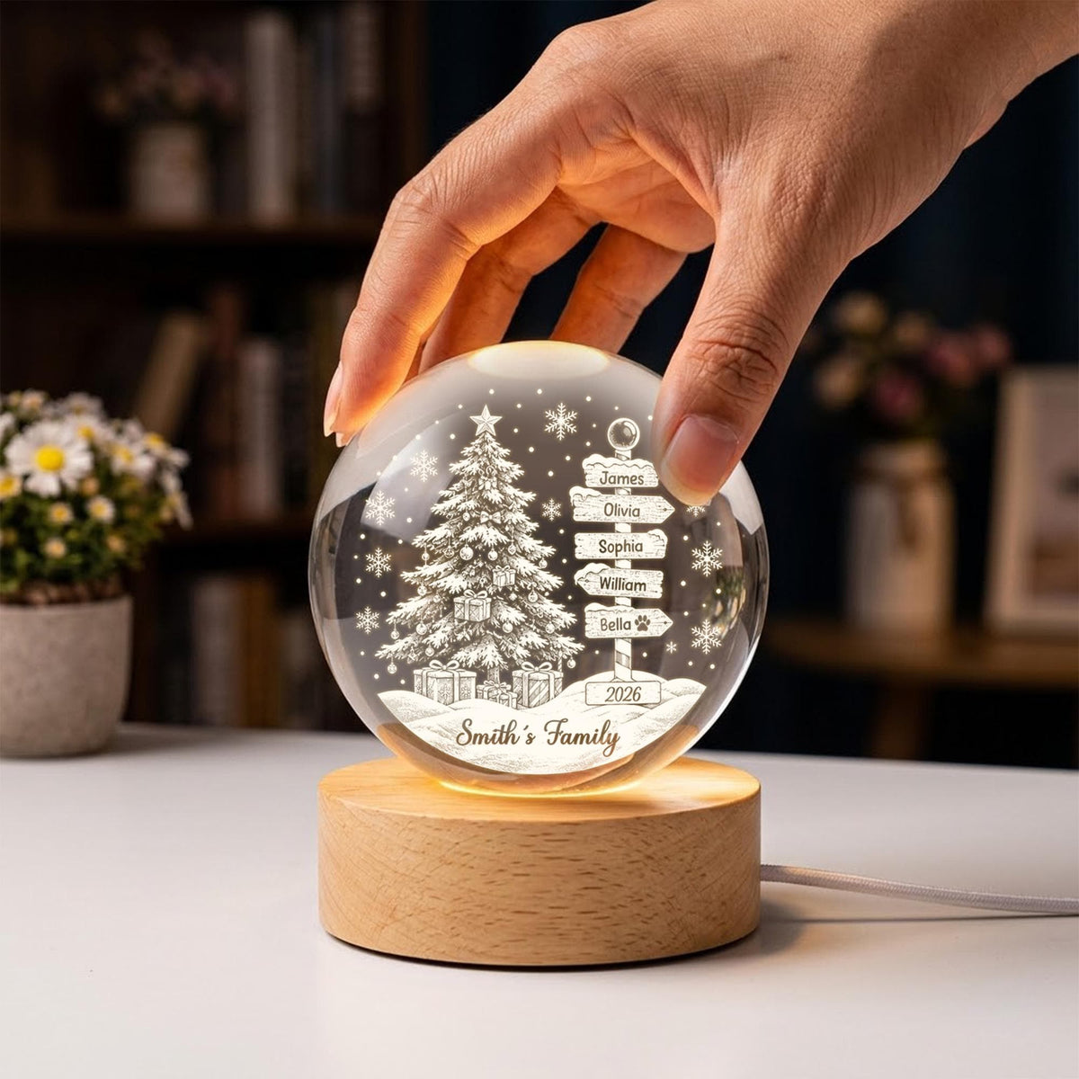 May include: A clear glass sphere night light featuring an etched Christmas tree, snowflakes, and a signpost with the names James, Olivia, Sophia, William, and Bella, plus the text Smith's Family and 2026, mounted on a round wooden base.