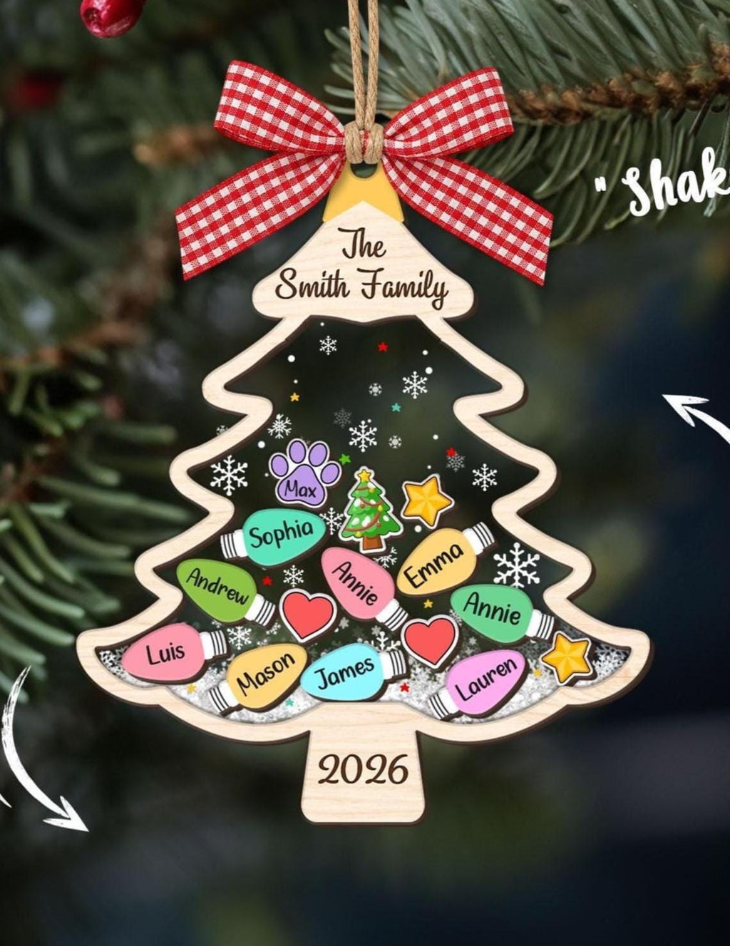 May include: A wooden Christmas tree-shaped shaker ornament featuring a red and white gingham bow, the text The Smith Family, and 2026. The center contains colorful light bulb shapes with names, a paw print, a heart, and a star, all over white glitter.