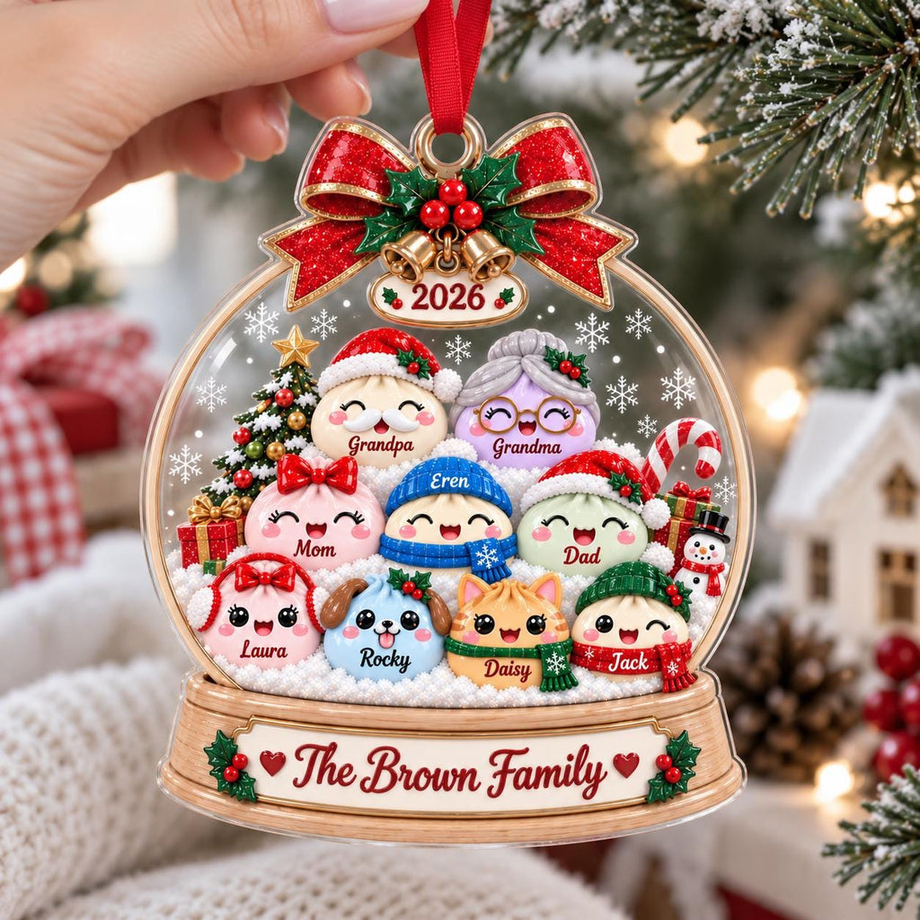 May include: A clear, globe-shaped Christmas ornament featuring a group of cartoon characters labeled Grandpa, Grandma, Mom, Eren, Dad, Laura, Rocky, Daisy, and Jack. The base displays the text The Brown Family and the year 2026 with a red bow.