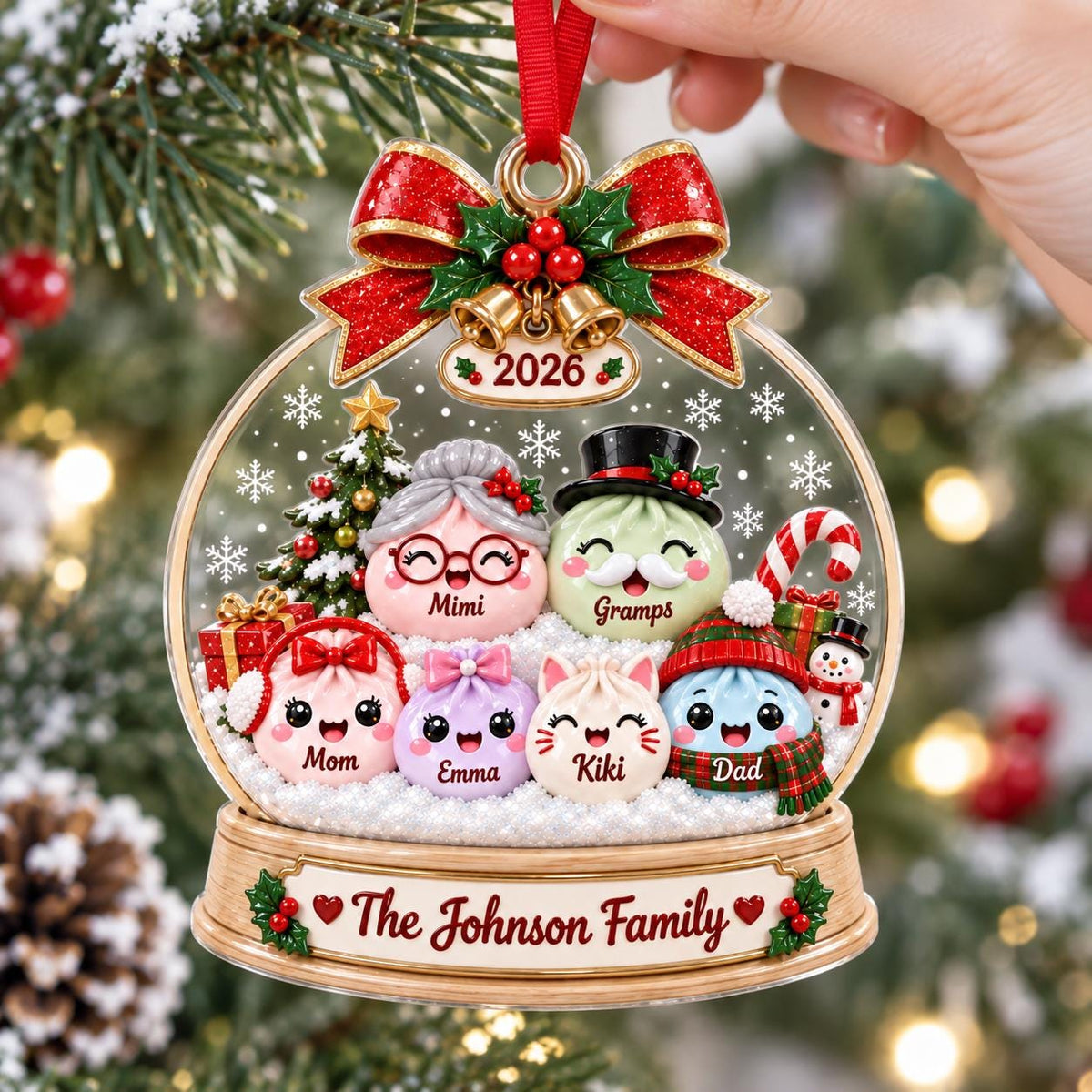 May include: A clear, globe-shaped Christmas ornament featuring a family of six cartoon characters with names Mimi, Gramps, Mom, Emma, Kiki, and Dad. The ornament is topped with a red bow, gold bells, and the year 2026. The base reads The Johnson Family.