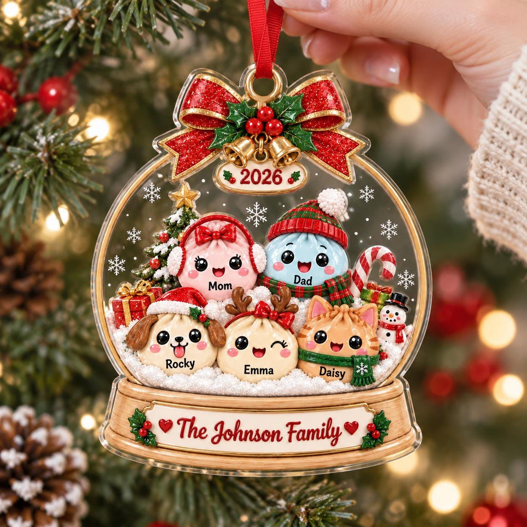May include: A clear, globe-shaped Christmas ornament featuring a red glitter bow and gold bells at the top. Inside are five cartoon characters labeled Mom, Dad, Rocky, Emma, and Daisy. The base displays the text The Johnson Family and the year 2026.