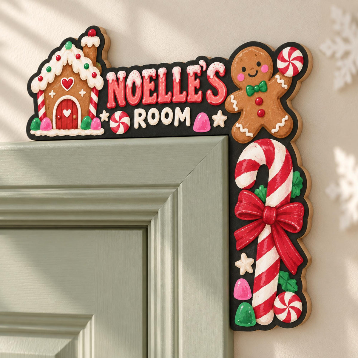 May include: A black L-shaped door corner sign featuring a gingerbread house, a gingerbread person holding a peppermint candy, and a large candy cane with a red bow. The text reads NOELLE'S ROOM in red and white letters with small candy accents.