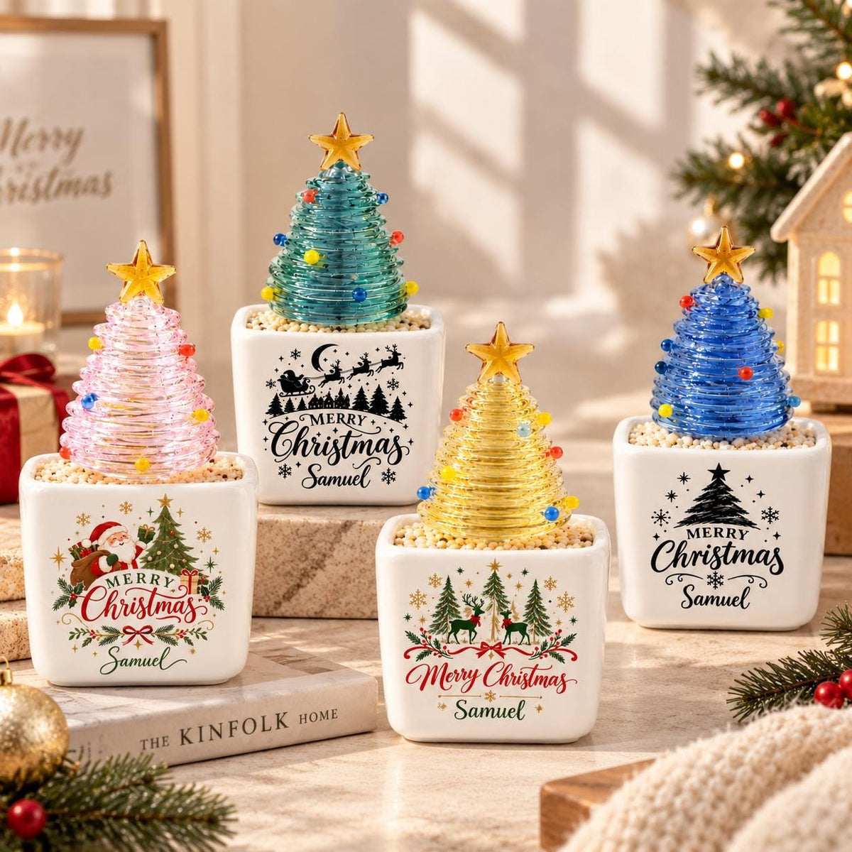 May include: Four square white ceramic planters each containing a coiled glass Christmas tree topped with a gold star. The planters feature festive holiday graphics, including Santa, reindeer, and the text Merry Christmas Samuel in black or red.