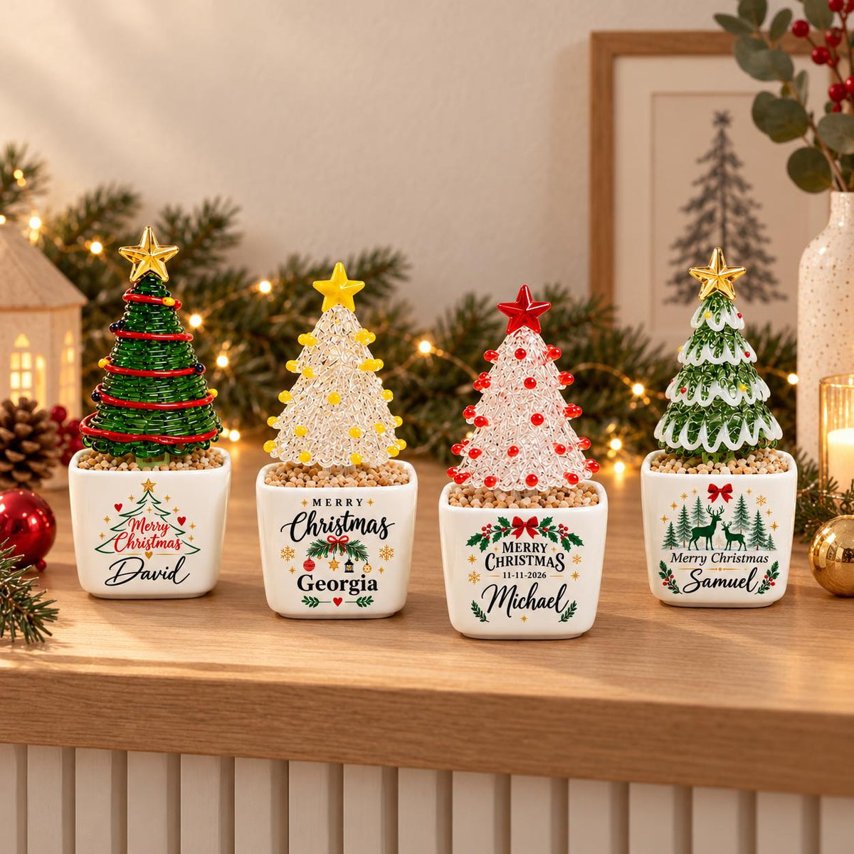 May include: Four miniature Christmas tree ornaments in square white ceramic pots. Each tree features a star topper and colorful beaded branches. The pots are printed with festive graphics and the names David, Georgia, Michael, and Samuel.