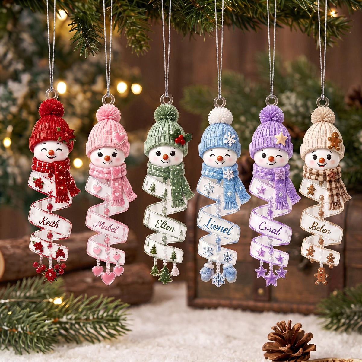 May include: Six hanging snowman ornaments with knit hats and scarves in red, pink, green, blue, purple, and beige. Each snowman features a spiral ribbon base printed with the names Keith, Mabel, Elton, Lionel, Coral, and Belen, accented with small charms.