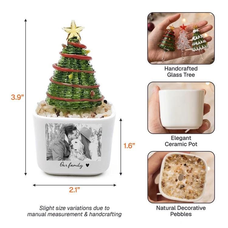 May include: A decorative glass Christmas tree with a gold star topper, wrapped in red wire, set in a white ceramic pot filled with natural pebbles. The pot features a black and white photo of a couple with a dog and the text Our family. Dimensions are 3.9 inches high and 2.1 inches wide.