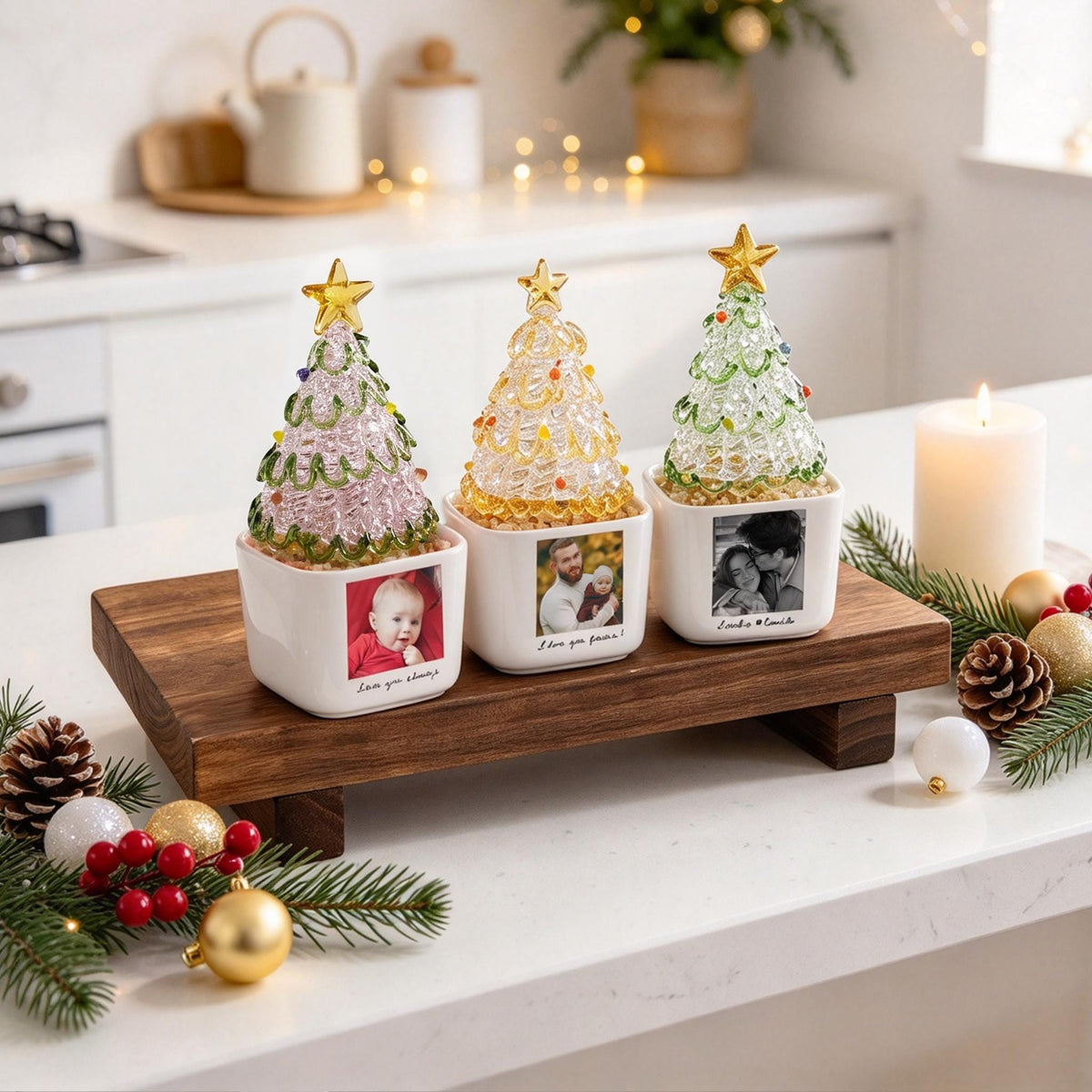 May include: Three glass Christmas tree ornaments in square white ceramic pots. Each tree features a gold star topper and colorful glass accents. The pots are personalized with printed photographs and text including Love you always, I love you forever, and a name.