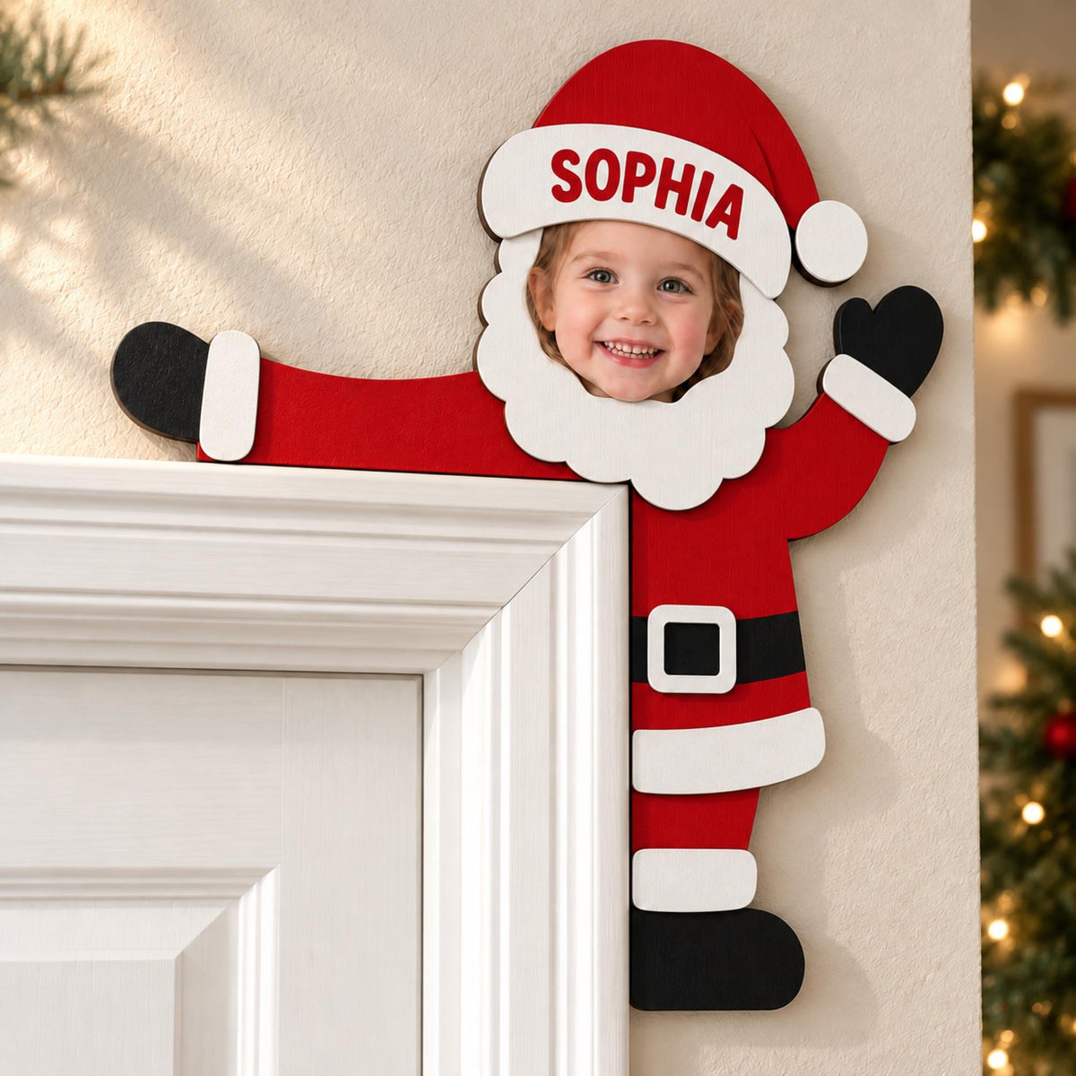 May include: A wooden Santa Claus door corner decoration featuring a red suit, black belt, and white trim. The design includes a cutout for a face, with the name SOPHIA printed in red on the white brim of the red Santa hat. The figure is positioned to appear as if peeking around the corner of a door frame.