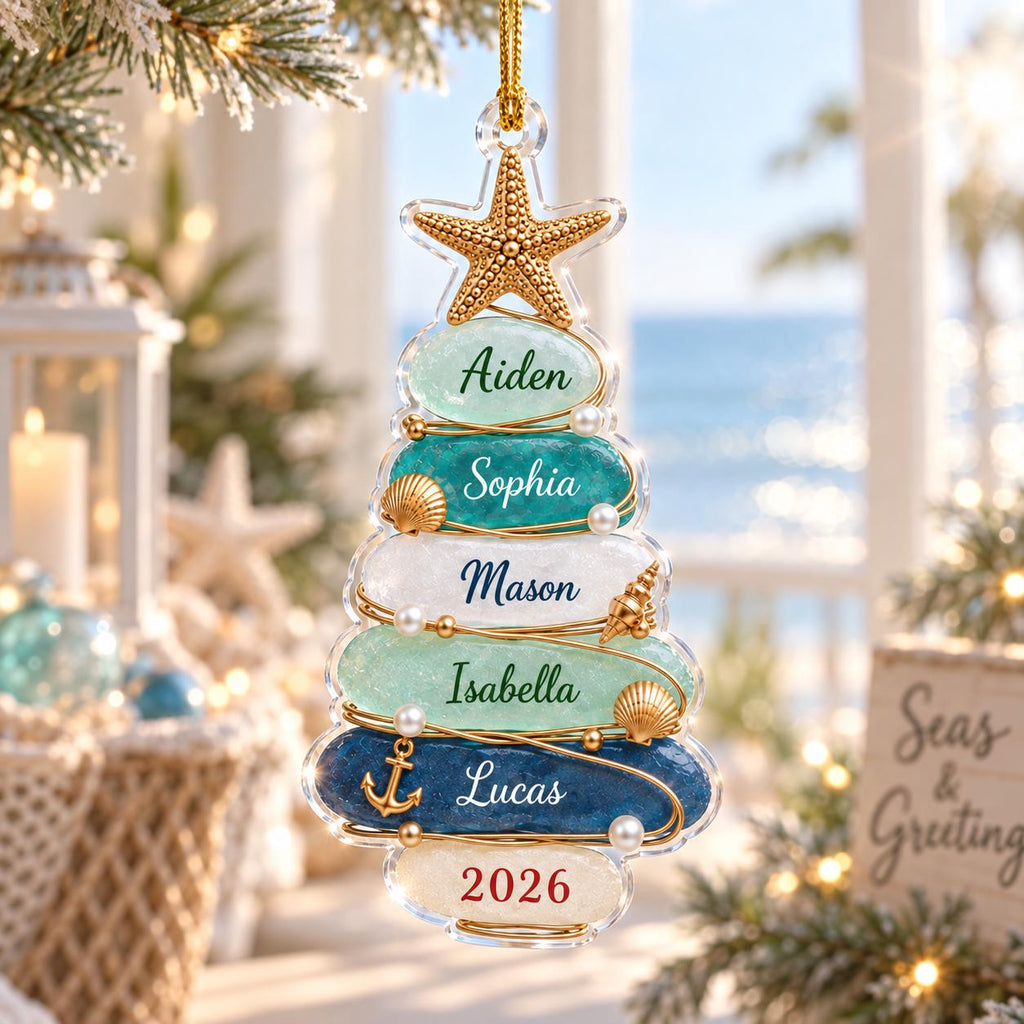 May include: A clear, tree-shaped Christmas ornament featuring stacked, textured glass-like layers in shades of blue, teal, and white. The ornament is topped with a gold starfish and decorated with small pearls, shells, and an anchor, with names and 2026 printed.