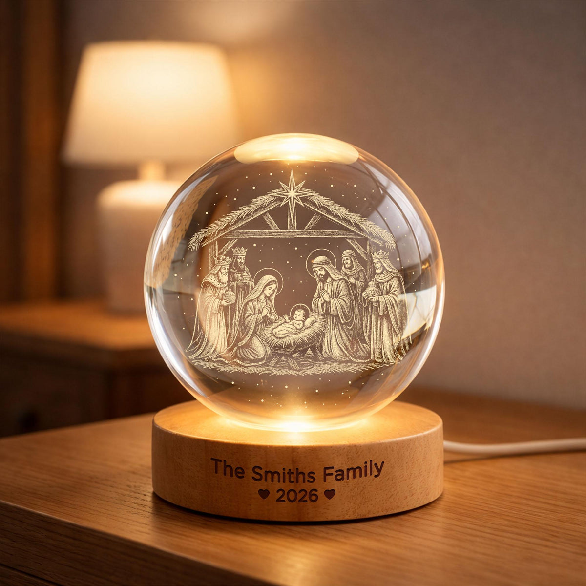 May include: A clear glass sphere featuring an internal laser-etched nativity scene with a star above. The sphere rests on a round wooden base illuminated from below, engraved with the text The Smiths Family and the year 2026 with heart icons.