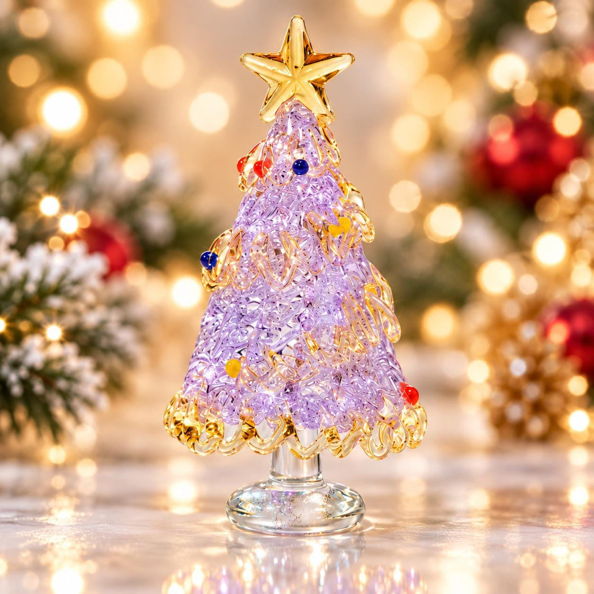 May include: A decorative glass Christmas tree figurine featuring a textured, light purple conical body adorned with small, colorful glass spheres and a gold-toned star topper. The tree stands on a clear, circular glass base with a scalloped edge.