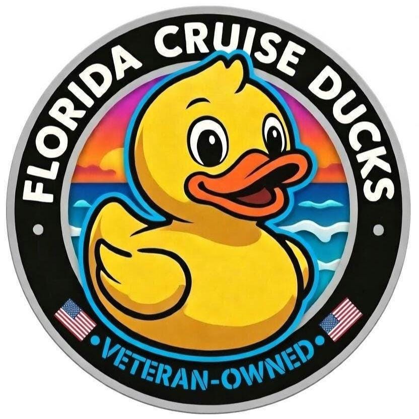 May include: A circular sticker featuring a yellow rubber duck with an orange beak centered against a sunset ocean background. The black border displays the white text FLORIDA CRUISE DUCKS and VETERAN-OWNED, accented by two small American flag icons.