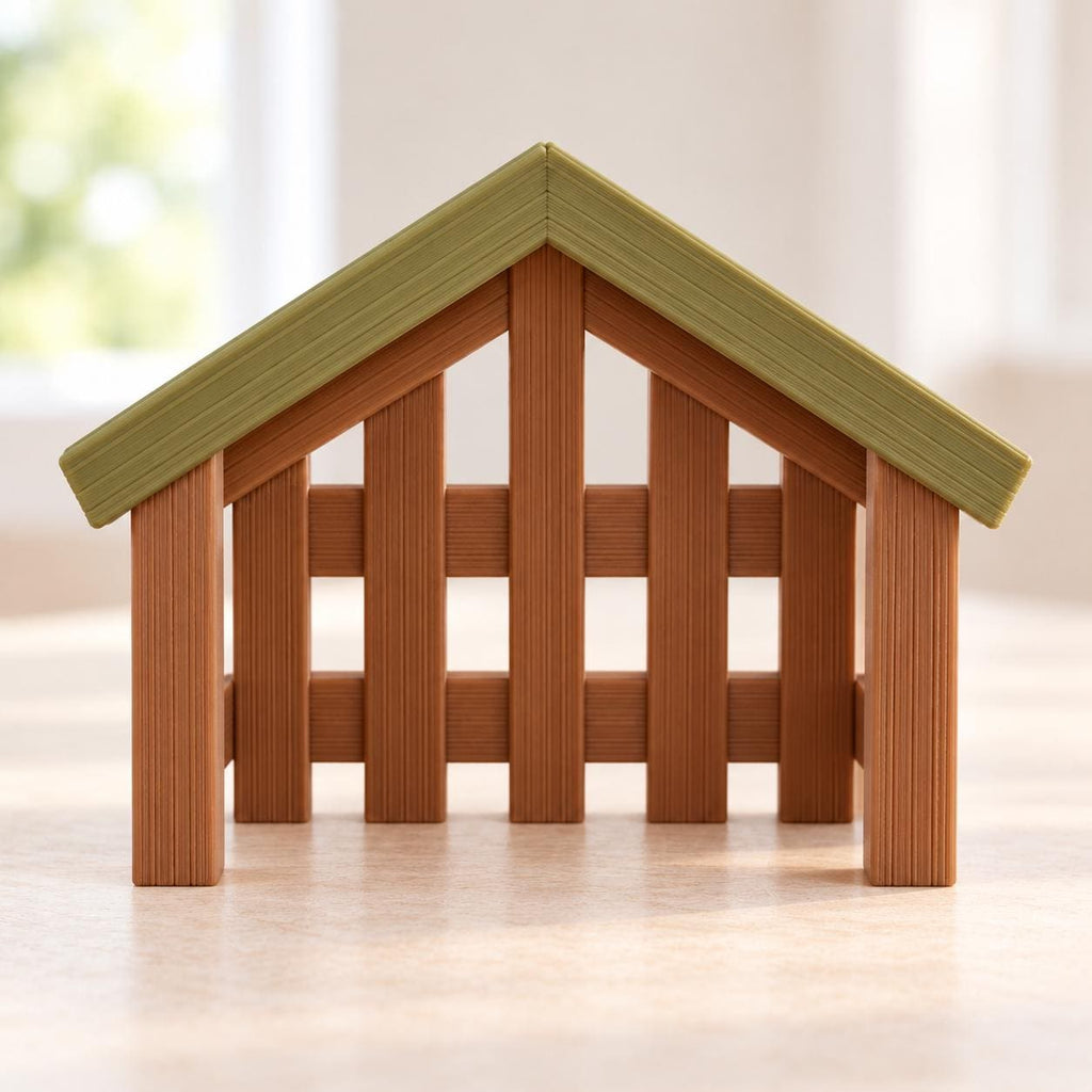 May include: A small, open-fronted structure resembling a stable or barn, featuring a light green triangular roof and vertical brown slats forming the walls. The design includes a central support post and a slatted fence-like appearance.