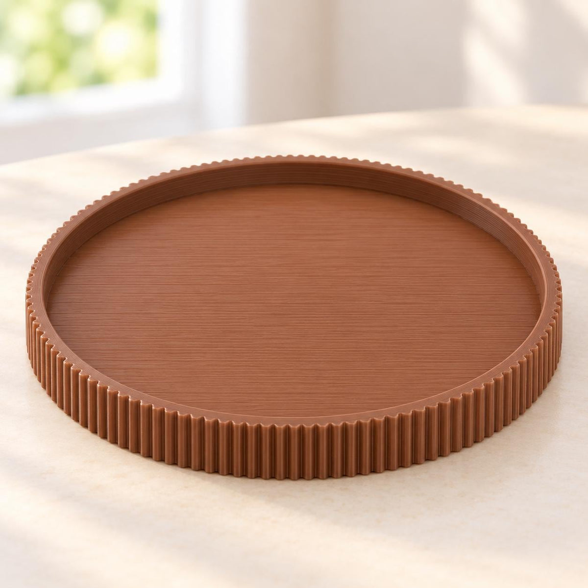 May include: A circular, medium-brown tray featuring a flat, smooth base and a raised, vertically ribbed outer edge. The tray has a consistent, solid color throughout and a clean, simple design with a defined rim that encircles the entire perimeter.