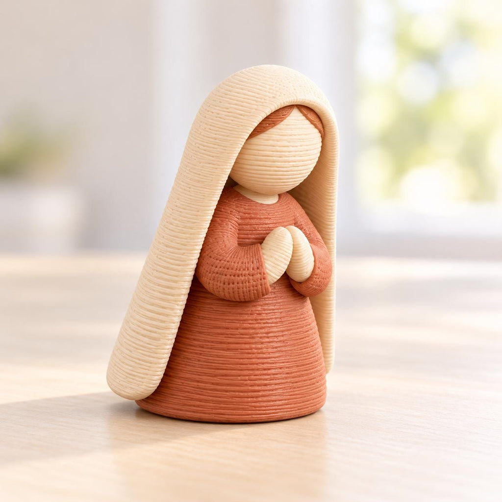 May include: A small, stylized figurine featuring a figure with a smooth, round head and hands clasped together in front. The figure wears a textured, terracotta-colored dress and a long, cream-colored head covering that drapes down the back.