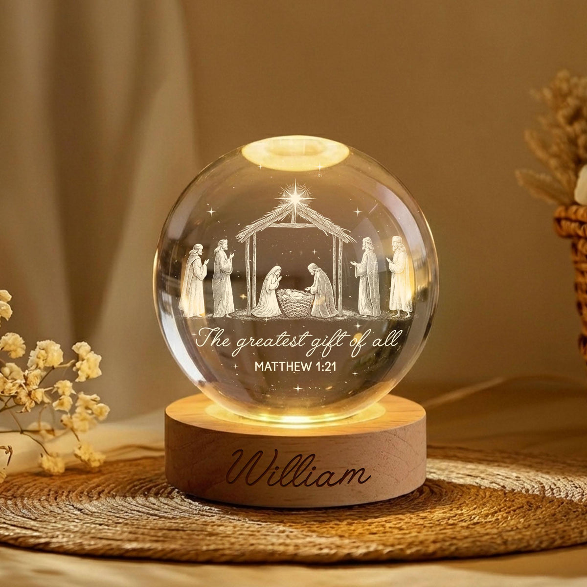 May include: A clear glass sphere lamp featuring an etched nativity scene with figures under a stable, the text "The greatest gift of all MATTHEW 1:21", and a light-colored wooden base engraved with the name "William" in cursive script.