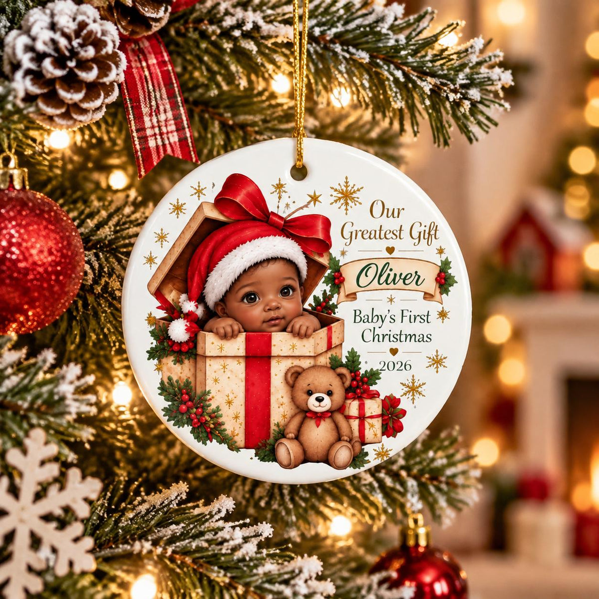 May include: A round white ceramic Christmas ornament featuring a baby in a Santa hat inside a gift box, a teddy bear, and the text Our Greatest Gift, Oliver, Baby's First Christmas, 2026. The design includes red ribbons, holly, and gold stars.
