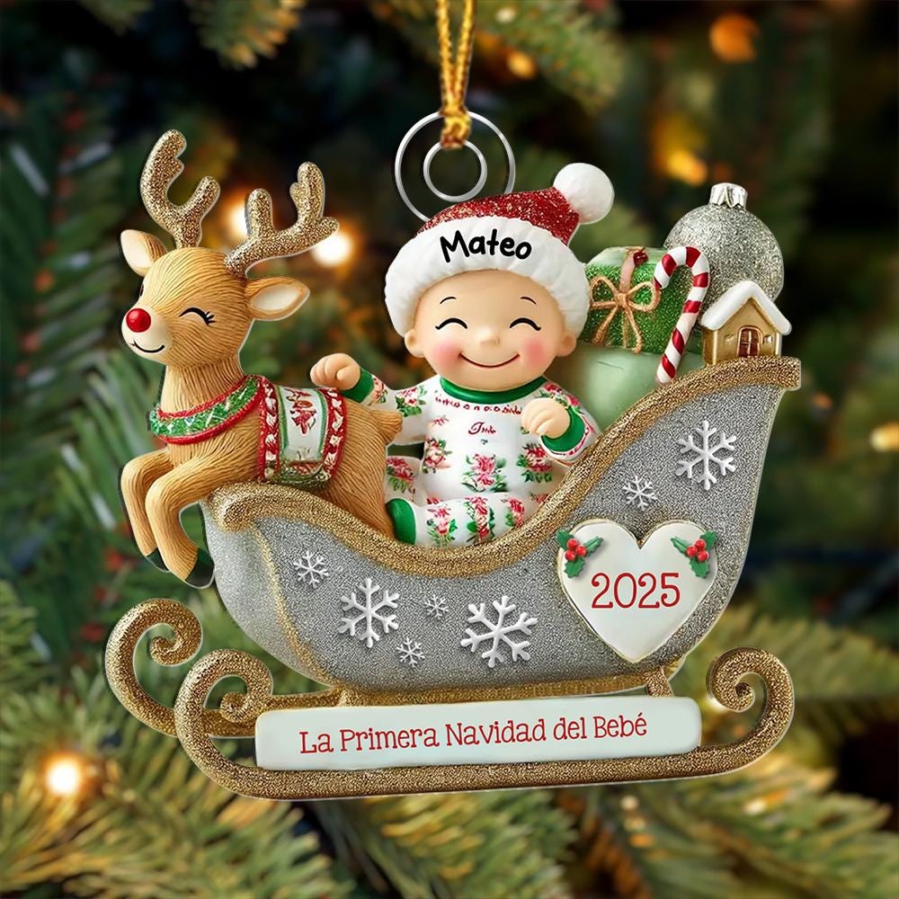 May include: A Christmas ornament featuring a baby in a silver glittery sleigh with a reindeer. The baby wears a hat labeled Mateo and pajamas. The sleigh has a heart with 2025, a candy cane, gifts, and a base with the text La Primera Navidad del Beb&eacute;.
