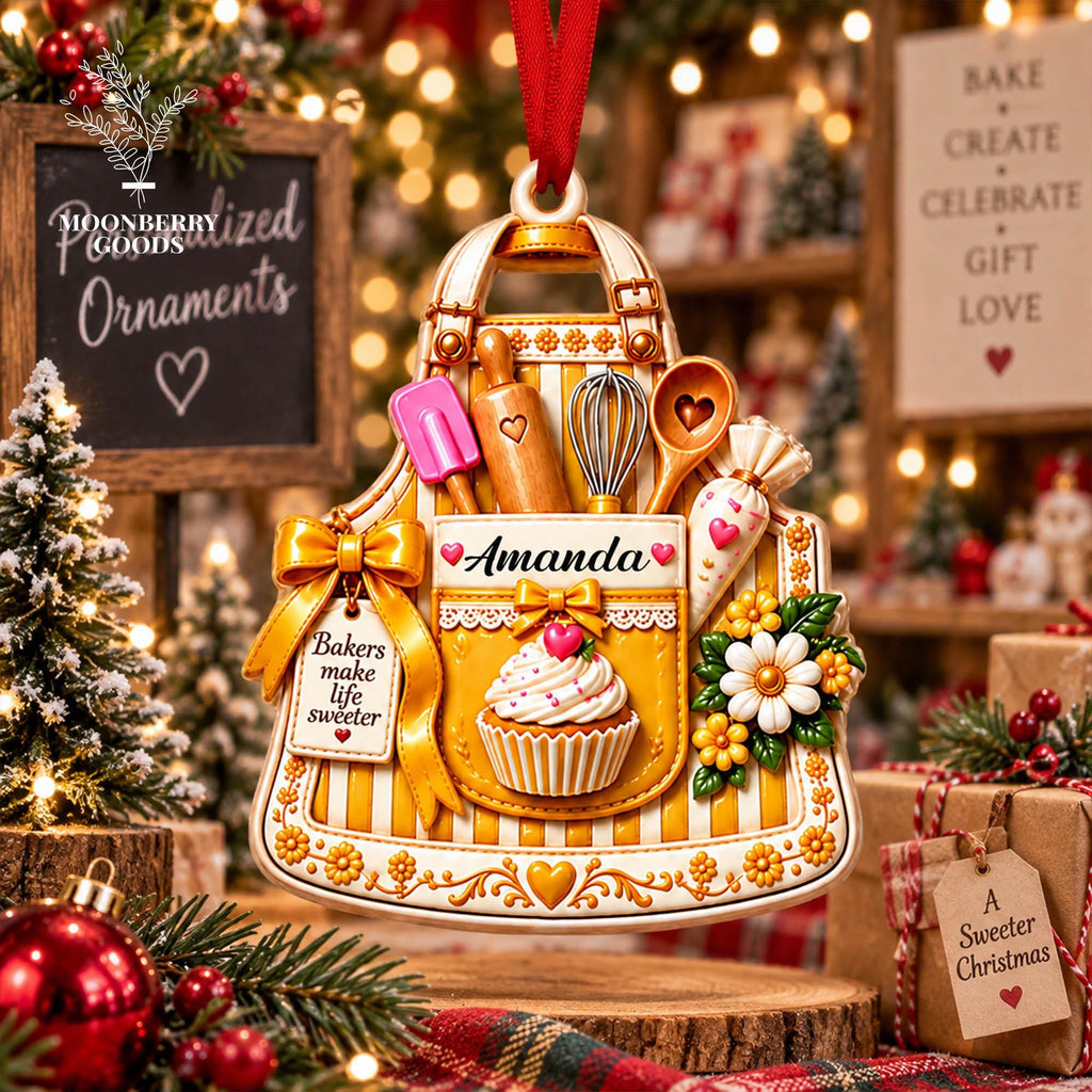 May include: A yellow and white striped apron-shaped Christmas ornament featuring a cupcake, a rolling pin, a whisk, a spatula, and a piping bag. The ornament displays the name Amanda and the text Bakers make life sweeter with a gold bow.