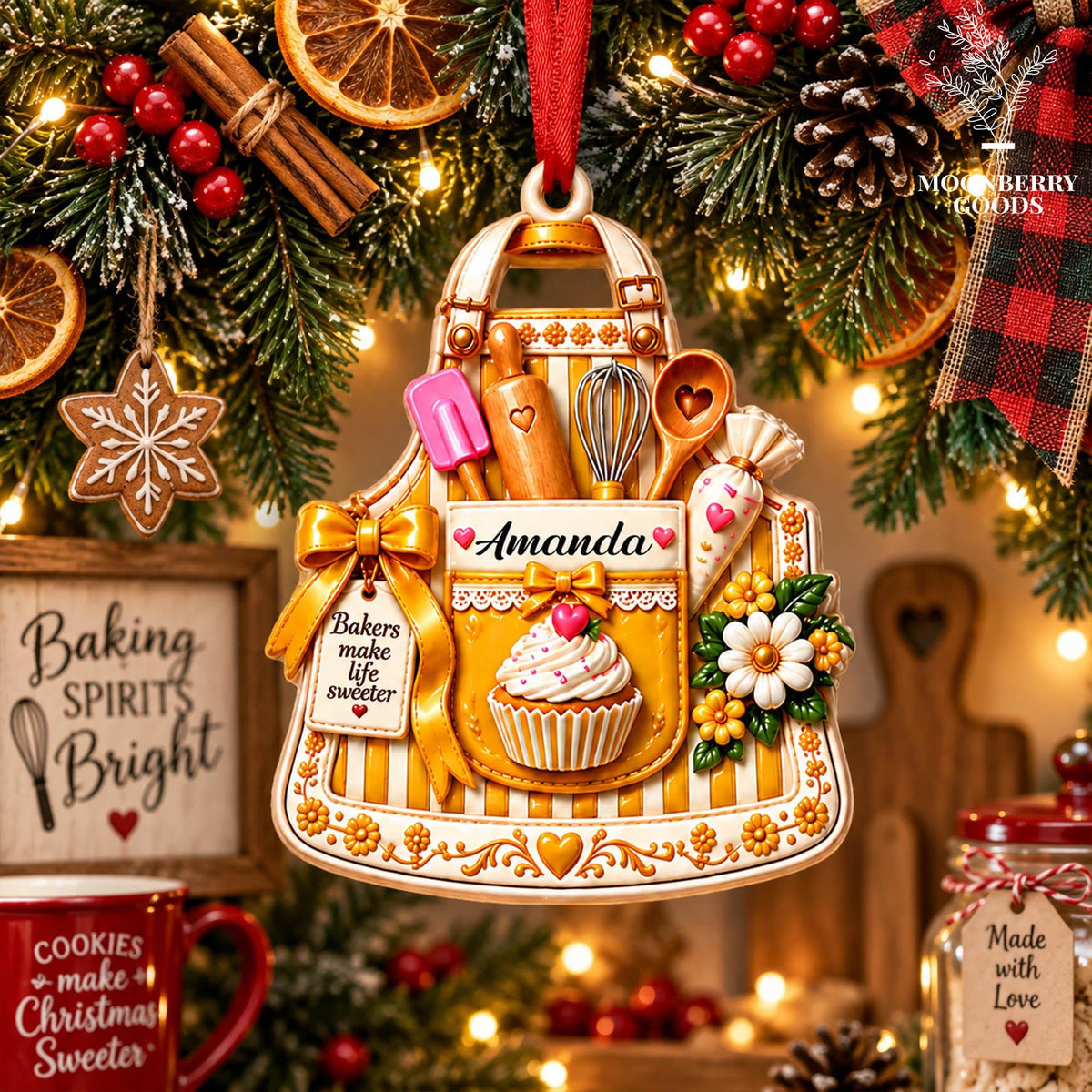 May include: A decorative apron-shaped ornament featuring a yellow and white striped pattern, a central pocket with the name Amanda, a cupcake, a whisk, a rolling pin, a spatula, a wooden spoon, and a tag reading Bakers make life sweeter.
