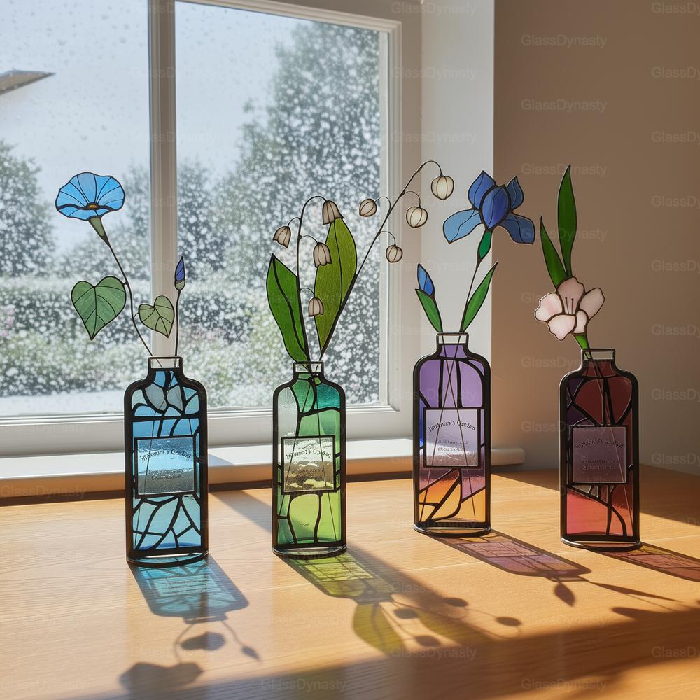 May include: Four stained glass vases with floral arrangements sit on a wooden surface near a window. The vases are rectangular with black outlines and contain blue, green, purple, and red hues. Each vase holds a different flower, including morning glories, lily of the valley, and irises.