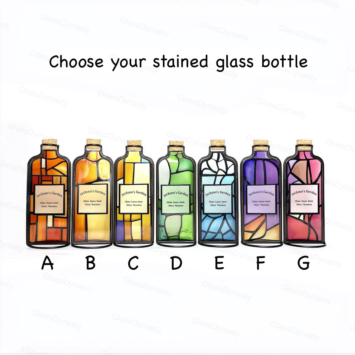 May include: Seven stained glass bottles with cork stoppers, each with a unique color scheme. The bottles are labeled A through G, and feature the text "Choose your stained glass bottle". Each bottle has a label that reads "Jackson's Garden".