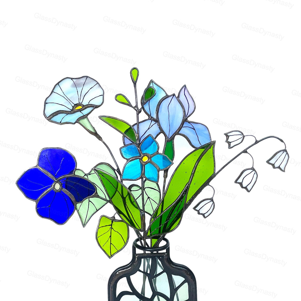 May include: Stained glass bouquet featuring blue and white flowers, green leaves, and a black vase. The flowers include morning glories, irises, and other blooms. The glass is outlined in black.
